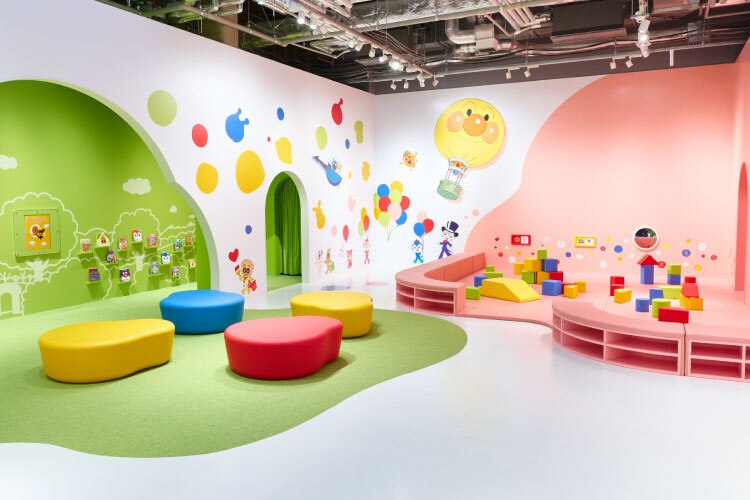 ベビーエリア＆えほんコーナーの全景。低いソファとブロックが並ぶ