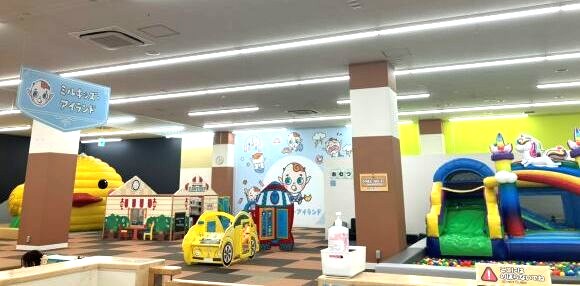 低い柵で囲まれた0〜2歳向けのスペースと、乗り物型の遊具