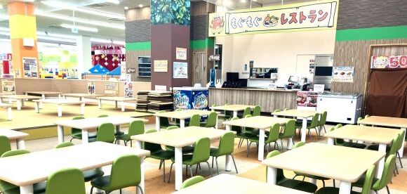 「もぐもぐレストラン」の看板と、並んだテーブルと椅子