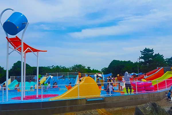 浅い水場のトドラーキッズスペース。バケツと滑り台がある