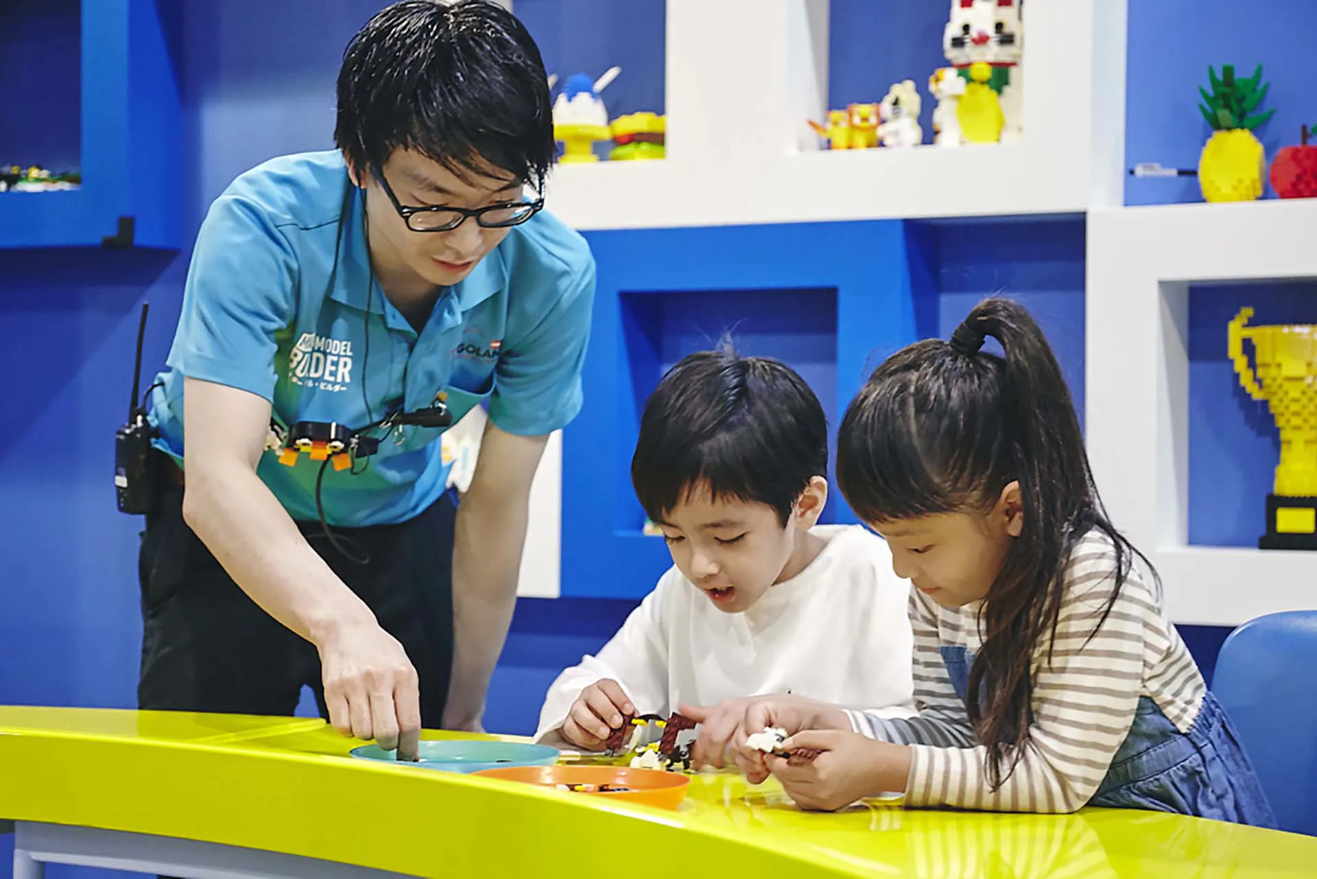 スタッフに教わりながらブロックを組む子どもたち