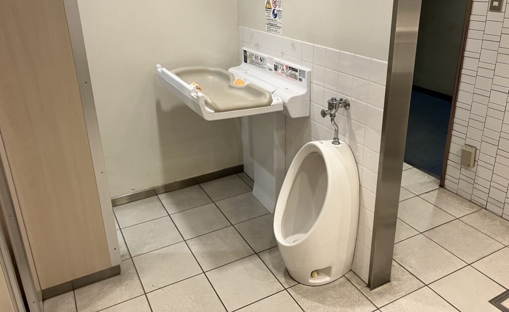 トイレ内のおむつ替えシートと男児用小便器