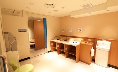 おむつ替え台が3台並び、奥に授乳用個室があるベビールーム