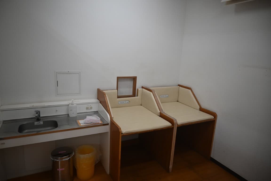 白い壁の部屋。左に流し台、右に木枠の授乳台が2つ並んでいる
