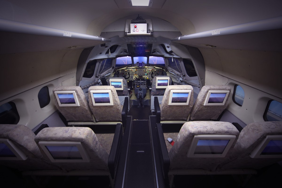 旅客機の客席とコックピットが並ぶシミュレーターの機内