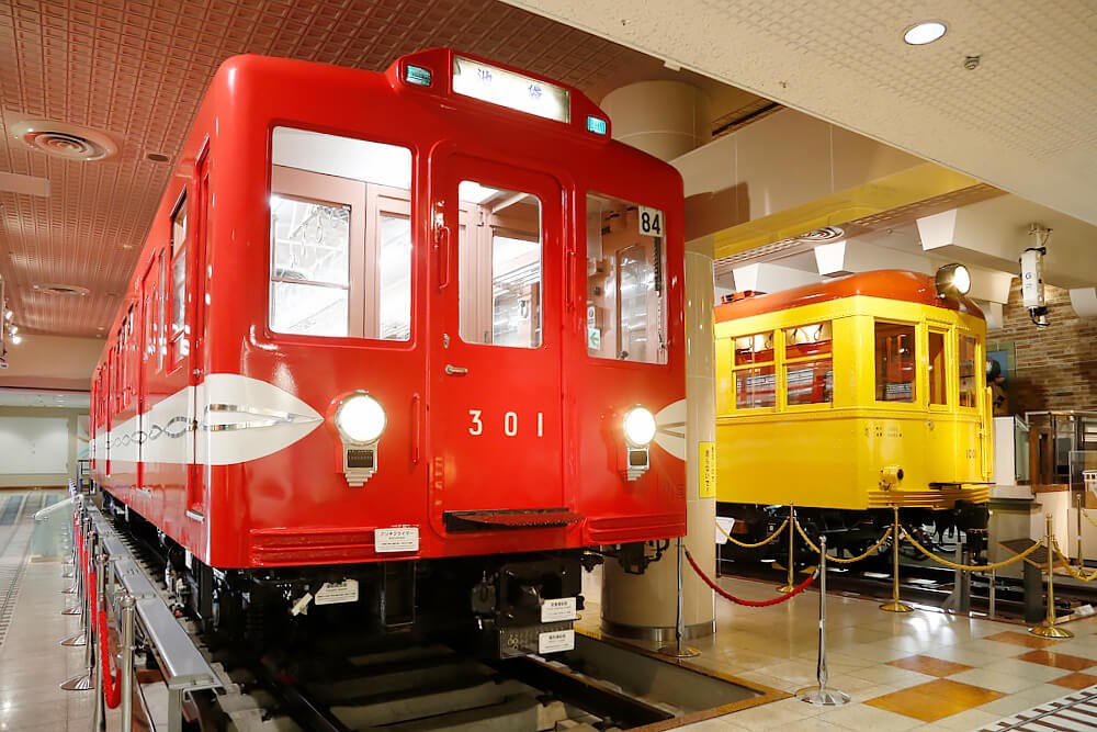手前に赤い車体の丸ノ内線301号車、奥に黄色い1001号車が並んで展示されている