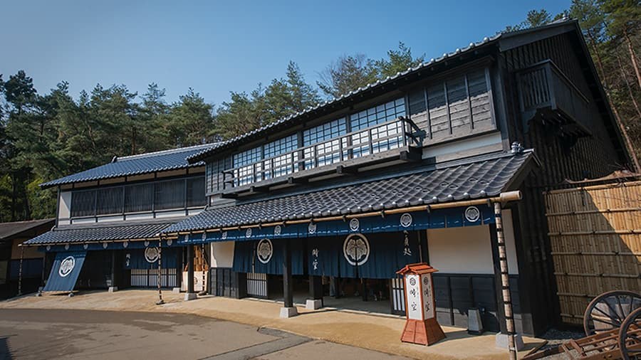なまこ壁の白と黒の外壁をもつ、横に長い二階建ての建物