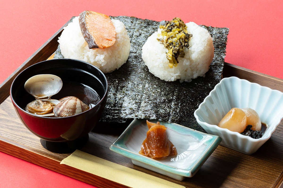海苔を巻いたおむすび2個と、あさりの汁物、小鉢が並んだ膳