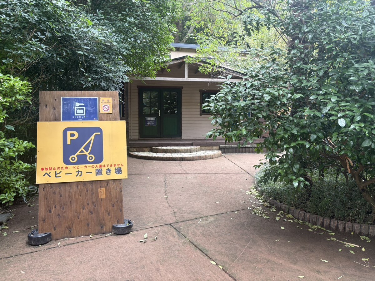 サユリワールドの臨時ベビーカー置き場。木の看板の奥に建物