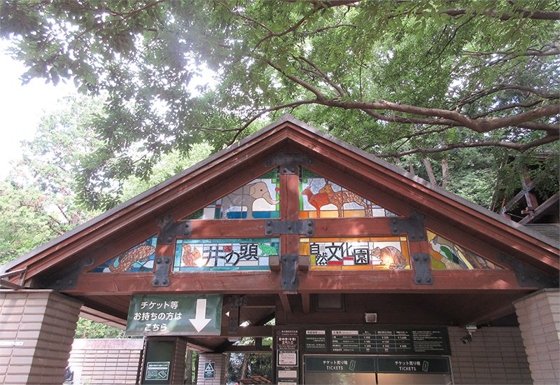 動物のステンドグラスと「井の頭自然文化園」の看板が付いた門。下にチケット売り場がある