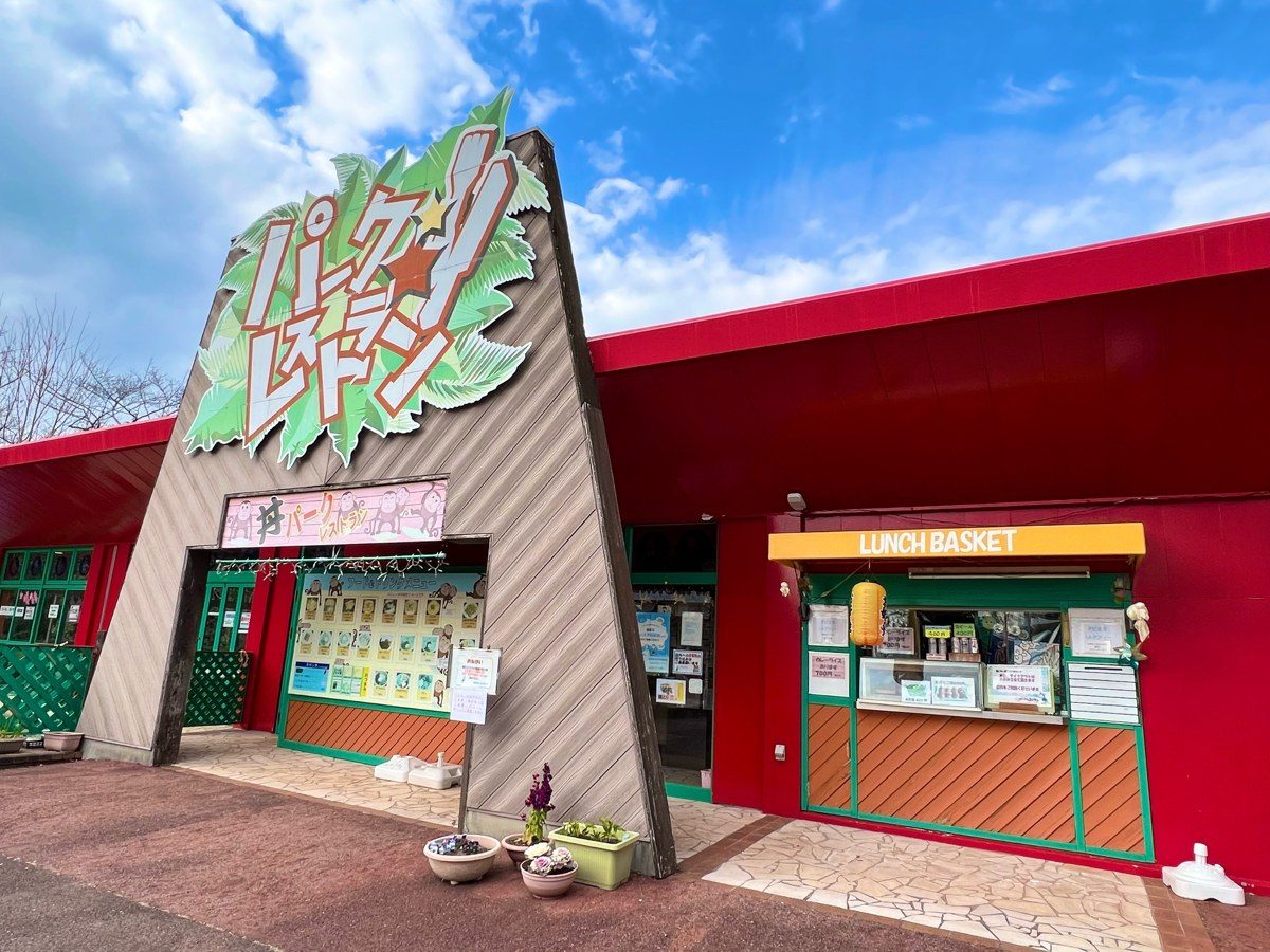 赤い壁に大きな看板を掲げたレストランの入口