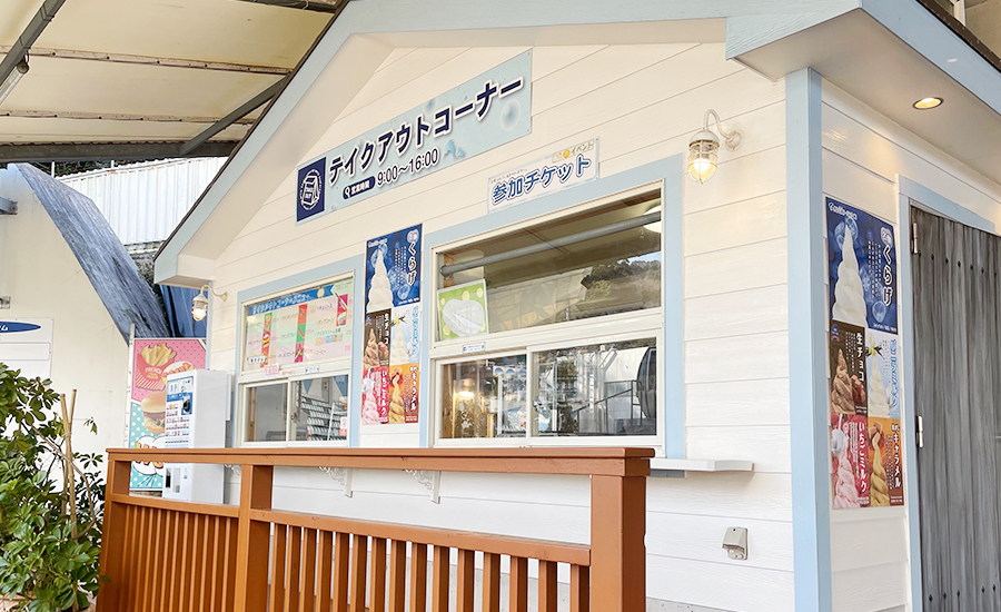 白い小屋に「テイクアウトコーナー」と「参加チケット」の看板が出ている