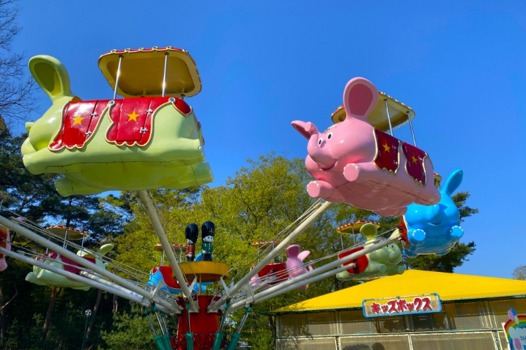 青空の下で回るゾウの形の乗り物
