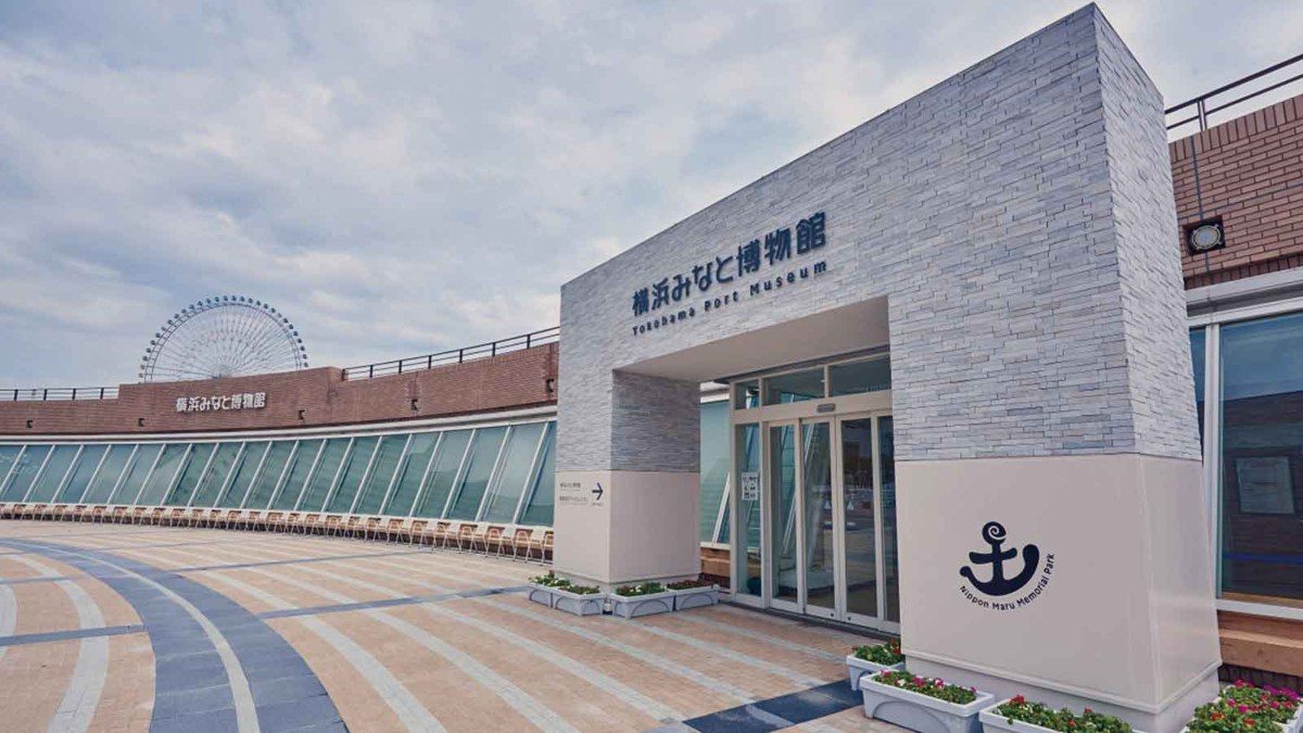 石積みの門構えに「横浜みなと博物館」と掲げられた入口。手前は平らな石畳の広場