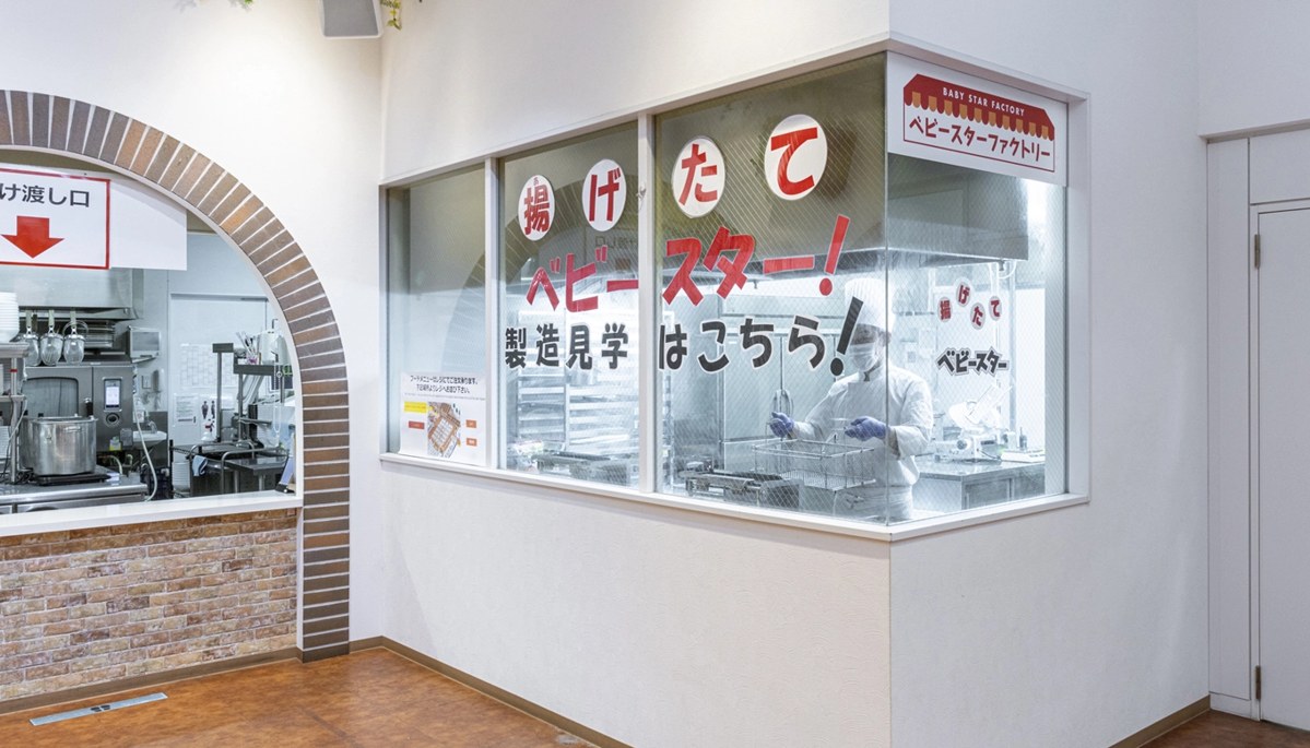 ガラス窓の向こうでベビースターを揚げる、ベビースターファクトリー