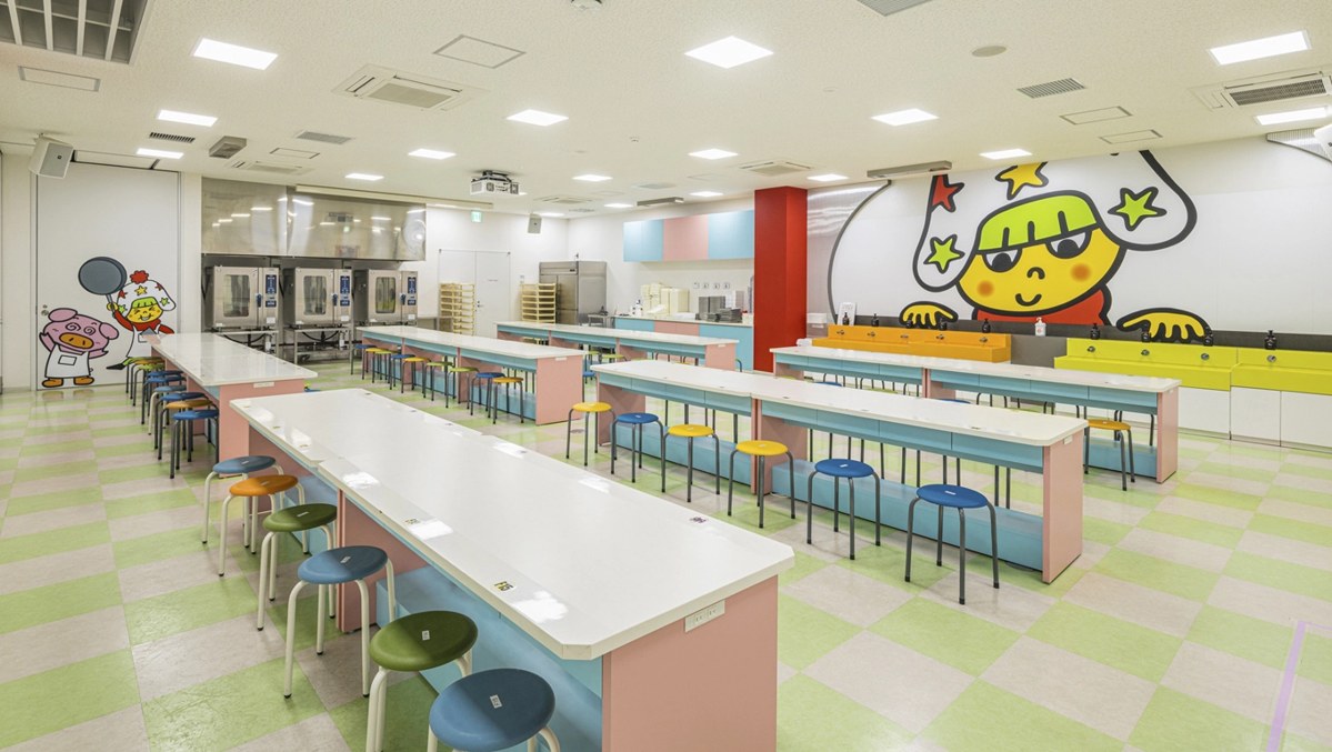 長い作業台と丸椅子が並ぶ体験プログラムの部屋