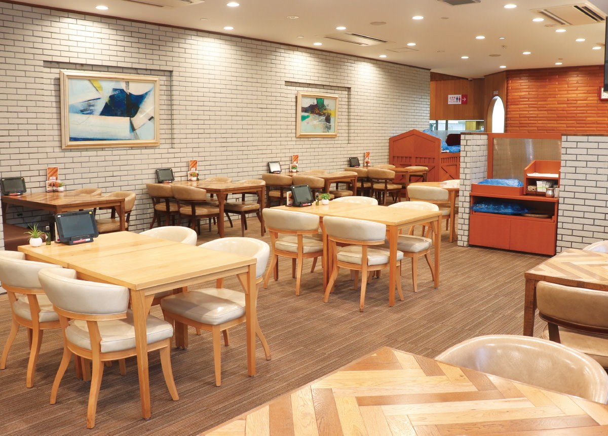 白いレンガ調の壁の店内に、木のテーブルと背もたれつきの椅子が並び、各テーブルに注文用のタブレット端末が置かれている