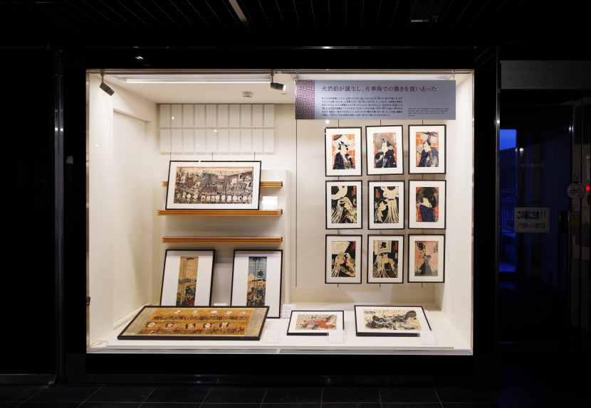 白い展示ケースの中に、江戸の火事を描いた錦絵が11点並べて掛けられている