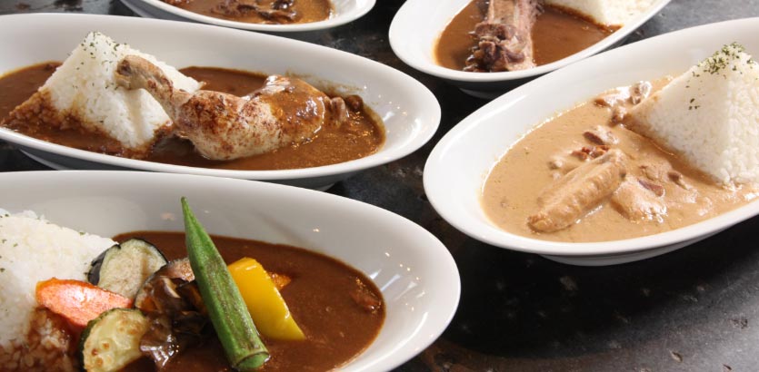 白い器に盛られた何種類ものカレー