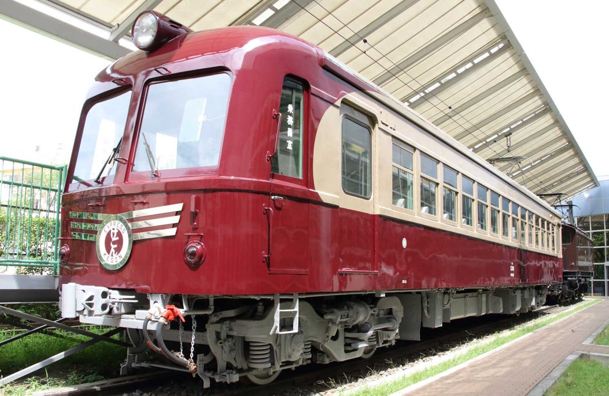 屋根の下に展示された臙脂色の特急電車。前面に「けごん」のヘッドマークが付いている