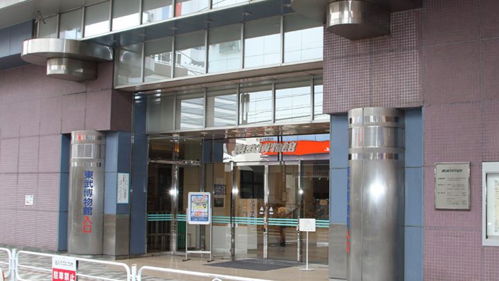 レンガ色の柱に「東武博物館 入口」と縦書きされた、ガラス張りの入口