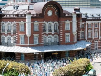 赤レンガの東京駅舎。駅前の広場に小さな人形が数えきれないほど並んでいる