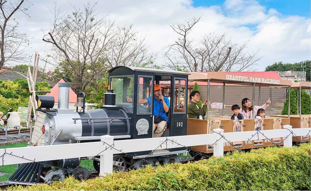 黒い機関車が客車を引いて走る、ハートフルファーム鉄道