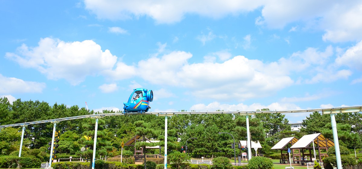 松林の上に渡されたレールを、水色の宇宙船の形をしたスカイサイクルが走っている