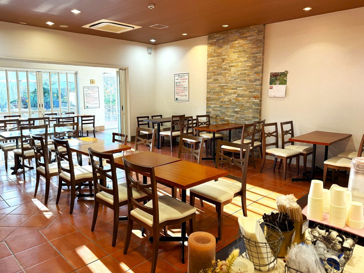 木のテーブルと椅子が並ぶカフェの店内