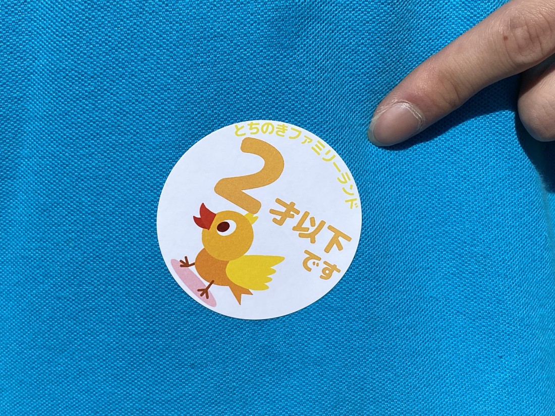 服に貼られた「2才以下です」と書かれたひよこのシール